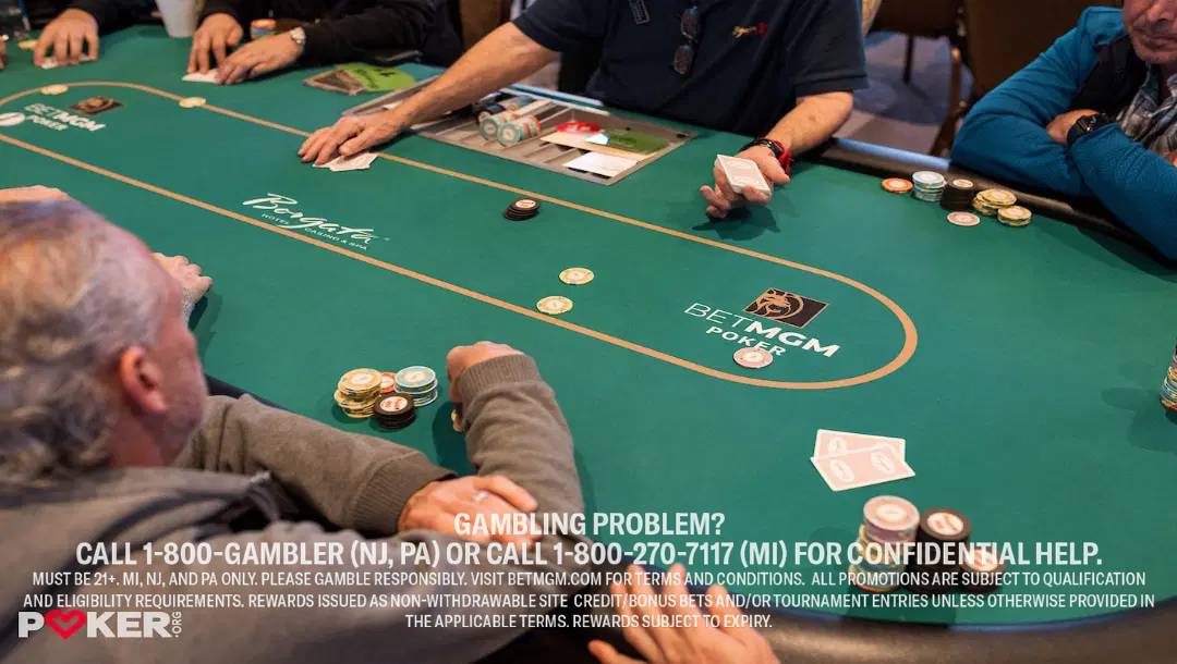 Players are gathered at a poker table, engaging in a card game with chips in play, set in a casino environment.