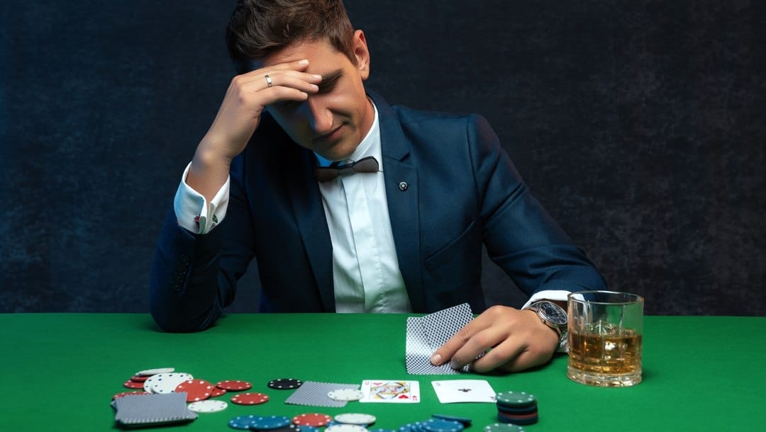 A-man-looks-with-concern-at-his-poker-cards-Weak-ace-hands