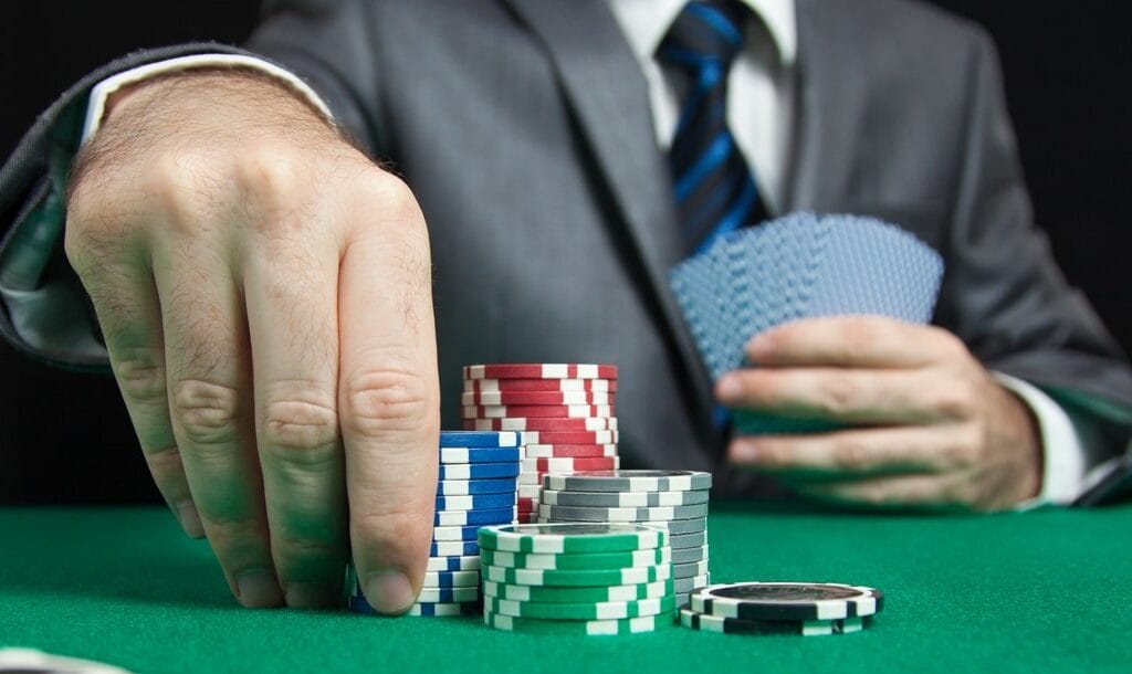 A-man-picks-up-a-stack-of-poker-chips-to-make-his-bet-Playing-flush-draws