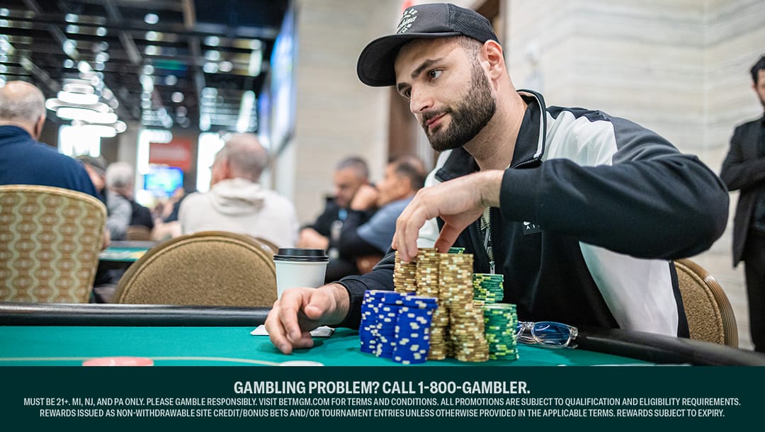 A professional poker player choosing poker chips from his large stacks.