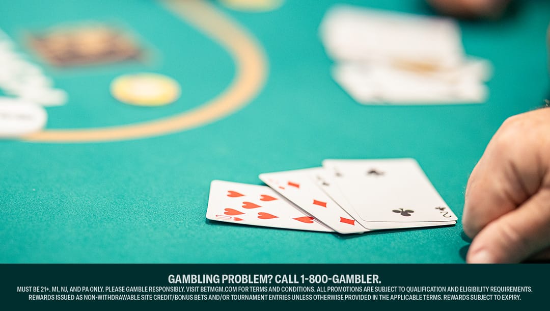 A four-card hand of cards on a green casino table.