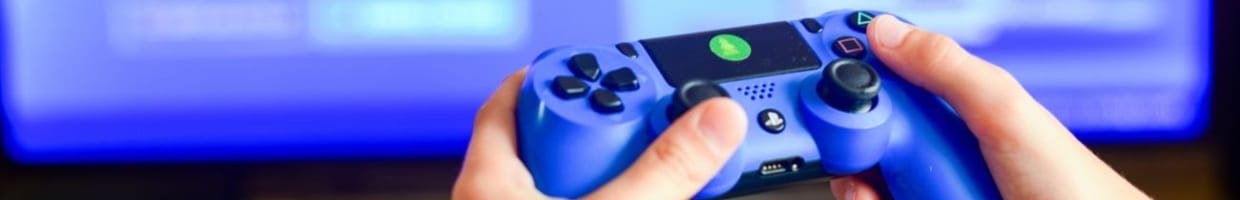 Gamer holding joystick and choosing players on gaming monitor.