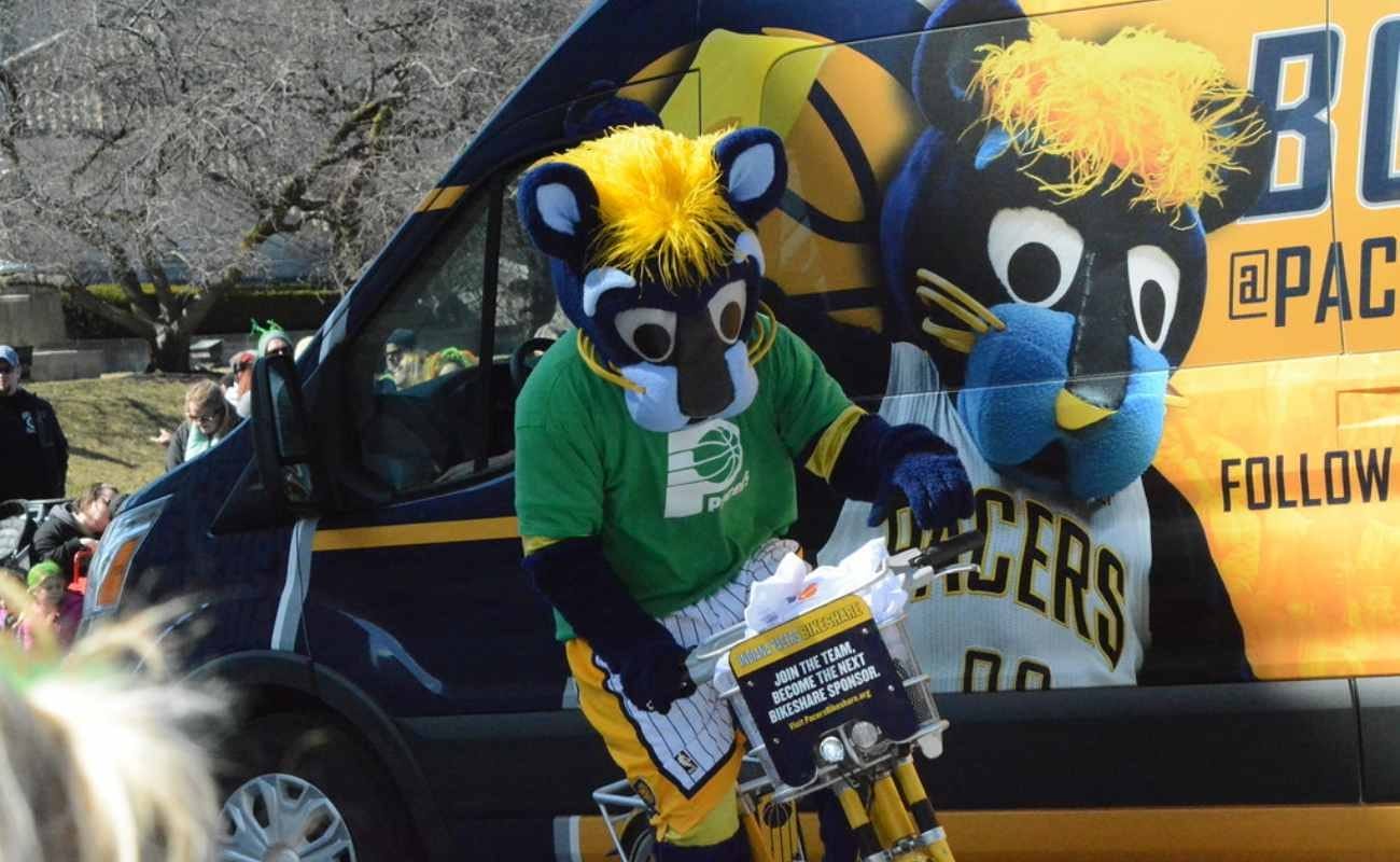 Indiana Pacers team mascot Boomer riding bike next to van