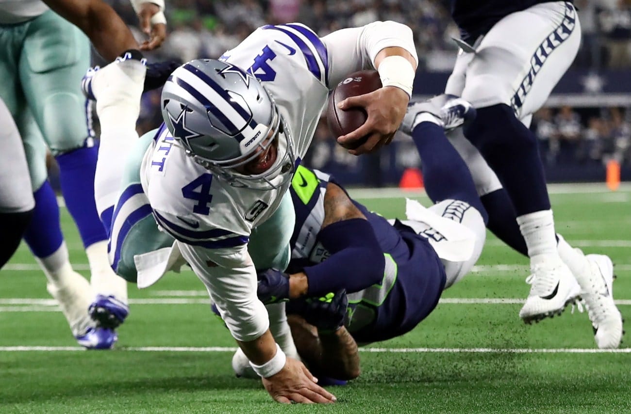 Dak Prescott #4 of the Dallas Cowboys dives to the 1-yard line while tackled by Bradley McDougald #30 of the Seattle Seahawks in the Wild Card Round at AT&T Stadium on January 05, 2019 in Arlington, Texas